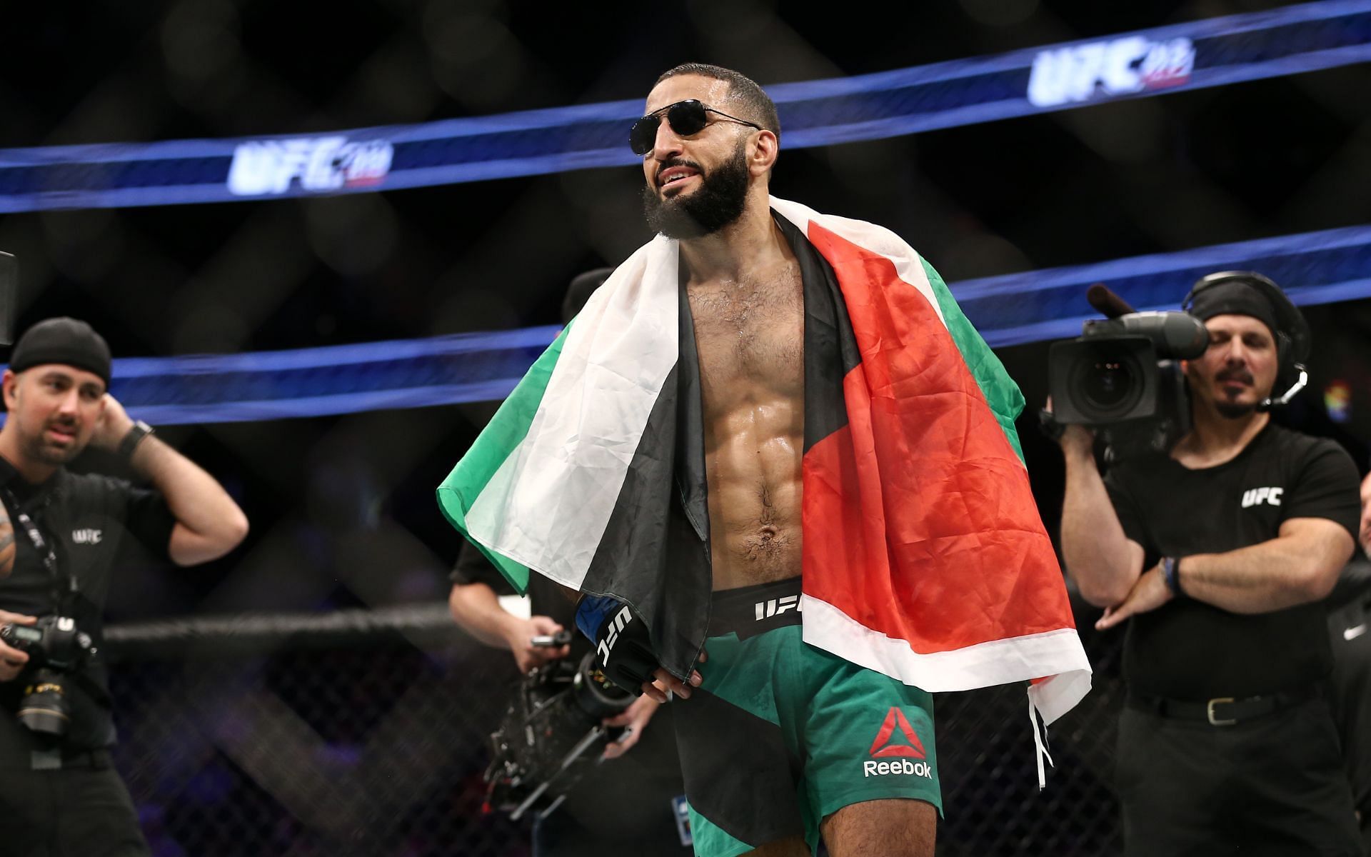Belal Muhammad with the Palestinian flag wrapped around him