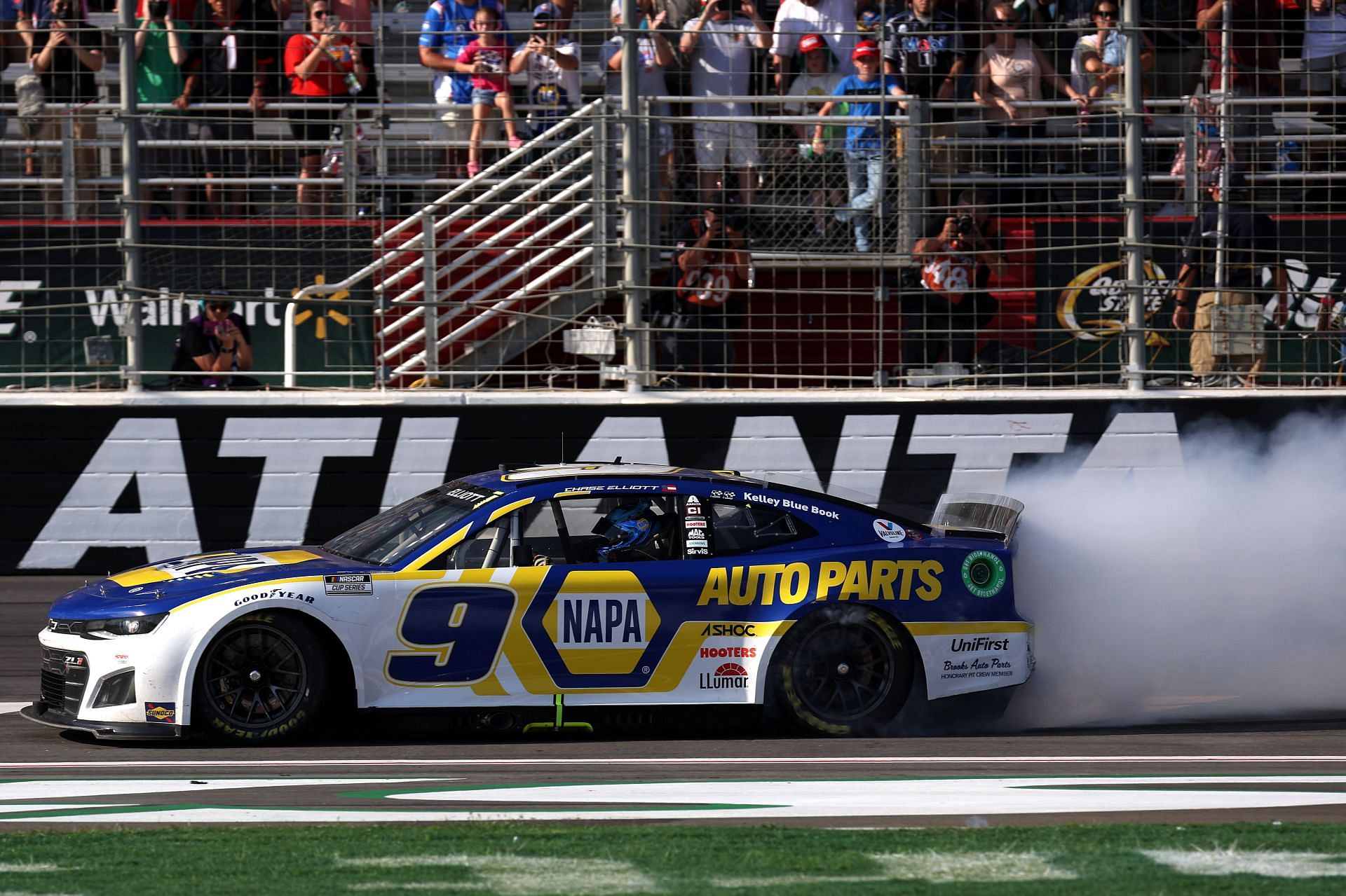 Chase Elliott celebrates with a burnout after winning the 2022 NASCAR Cup Series Quaker State 400 at Atlanta Motor Speedway in Hampton, Georgia (Photo by James Gilbert/Getty Images)