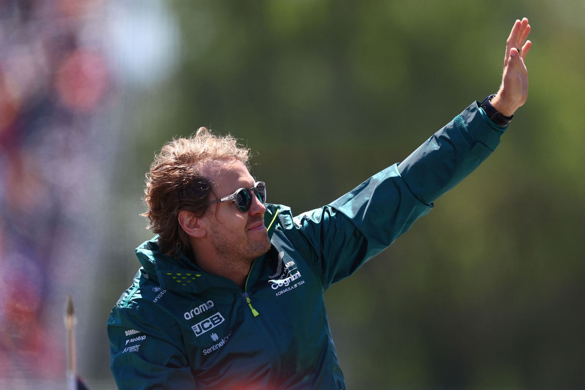 Aston Martin F1 driver Sebastian Vettel waves to the crowd from the drivers&#039; parade ahead of the 2022 F1 Grand Prix of Canada at Circuit Gilles Villeneuve in Montreal, Quebec (Photo by Clive Rose/Getty Images)