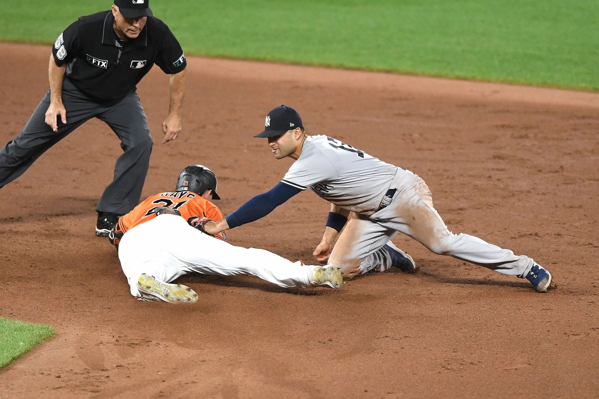 Baltimore Oriole Austin Hays avoids the tag of New York Yankees shortstop Isiah Kiner-Falefa