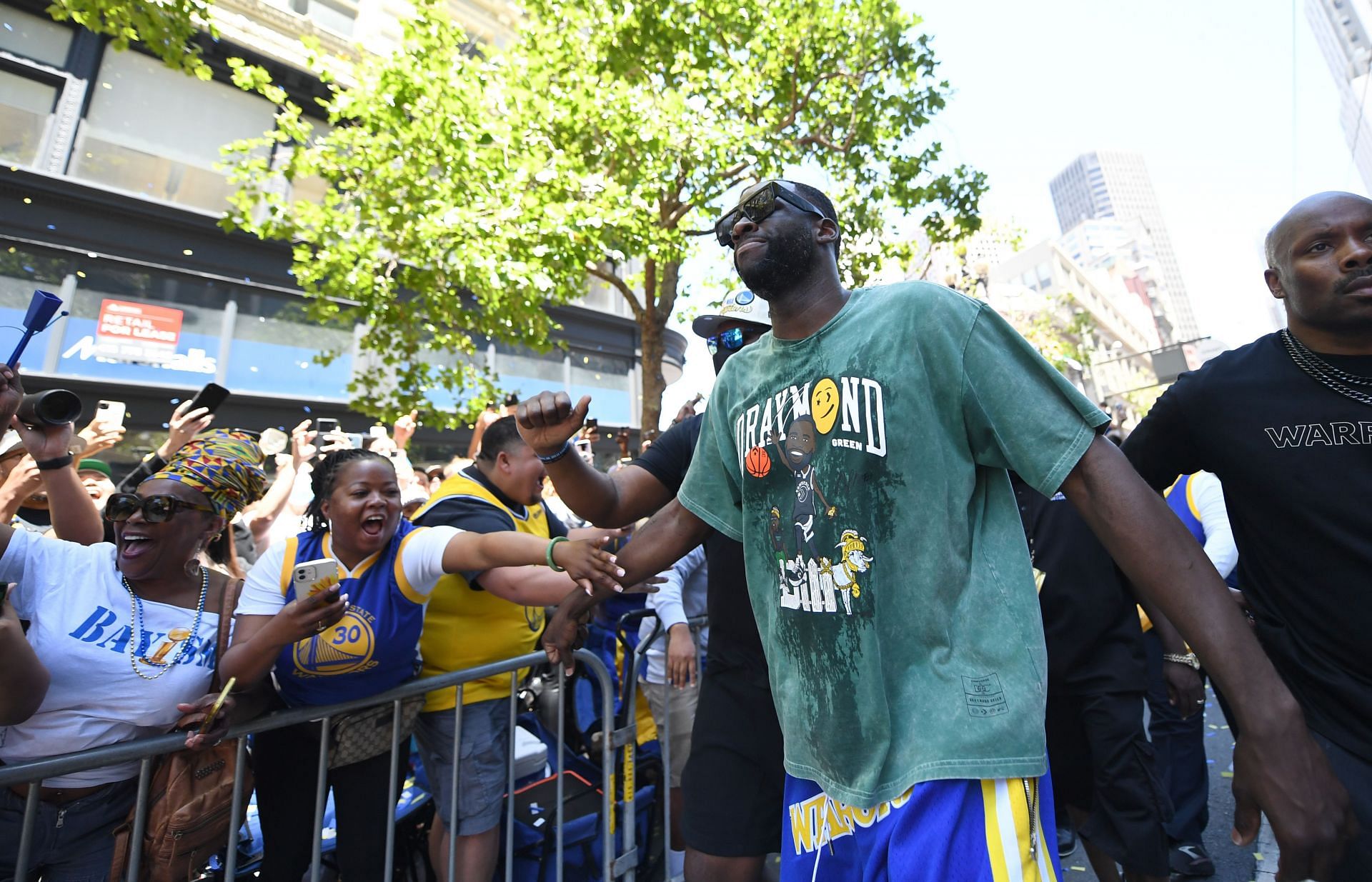 Draymond Green of the Golden State Warriors high fives fans during their victory parade and rally on June 20 in San Francisco, California. The Warriors beat the Boston Celtics 4-2 to win the NBA Finals.