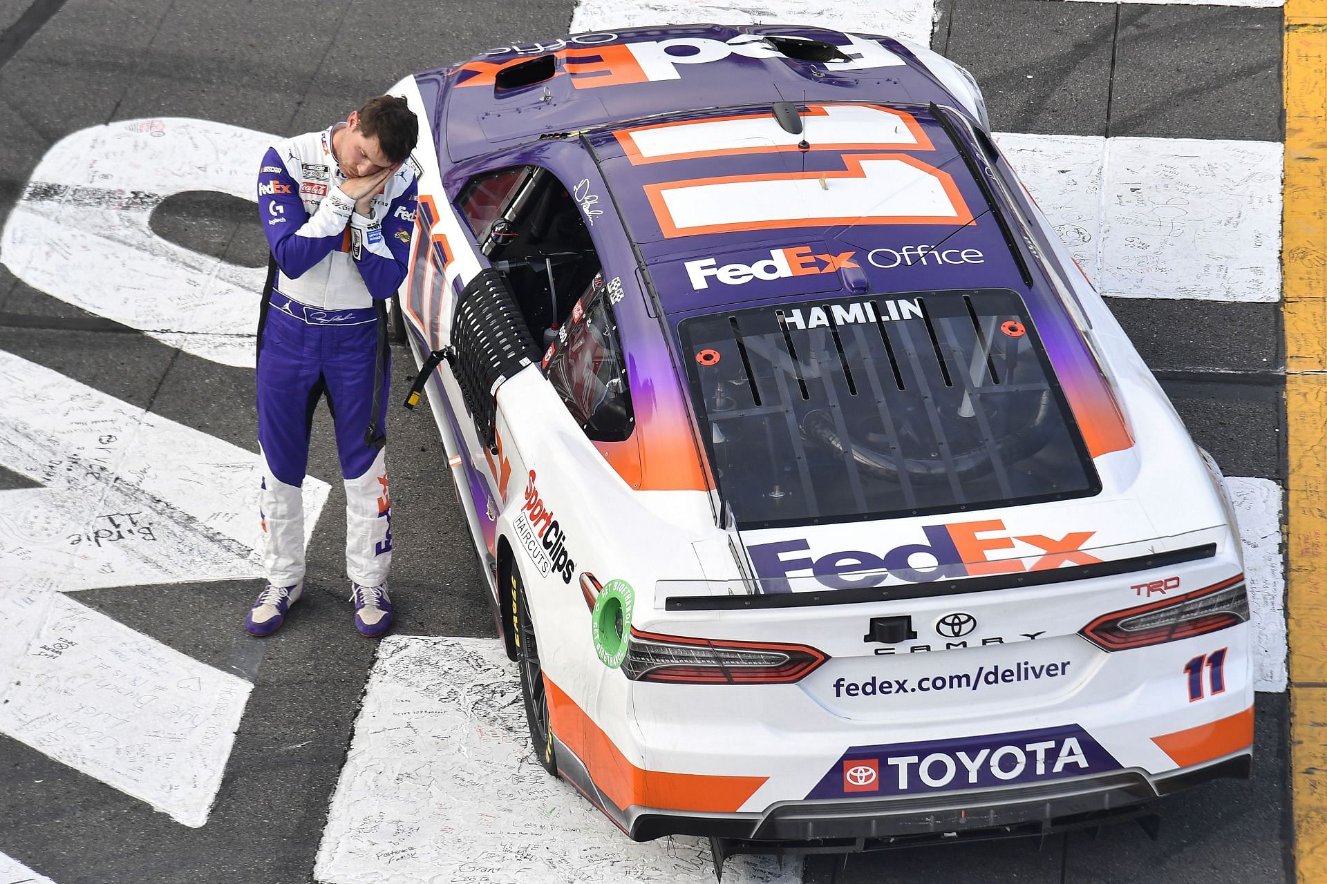 Denny Hamlin puts on a sleeping gesture at the 2022 NASCAR Cup Series M&amp;M&#039;s Fan Appreciation 400 at Pocono Raceway in Long Pond, Pennsylvania (Photo by Logan Riely/Getty Images)