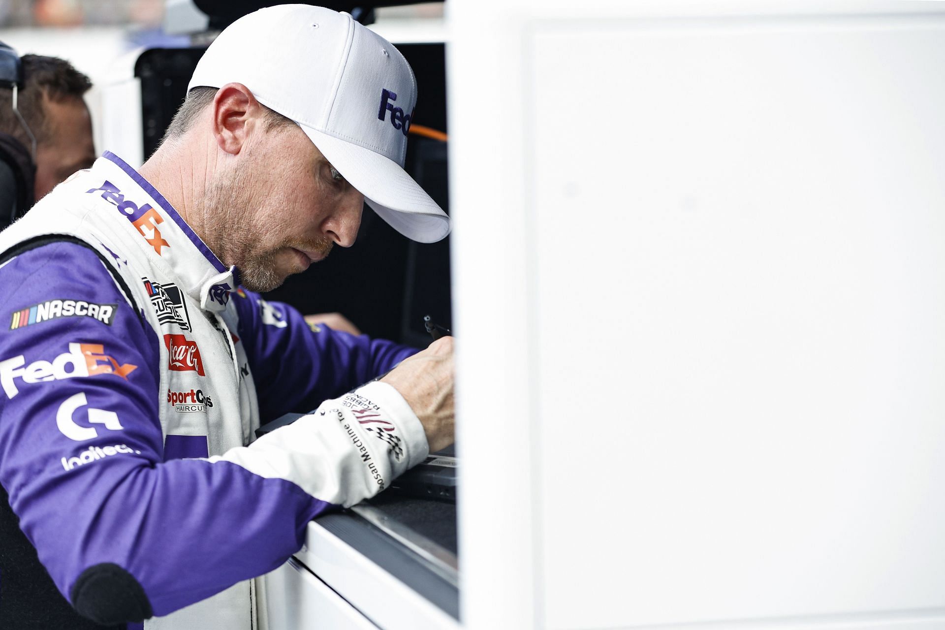 Denny Hamlin works in the garage area during practice for the NASCAR Cup Series FireKeepers Casino 400 at Michigan International Speedway.