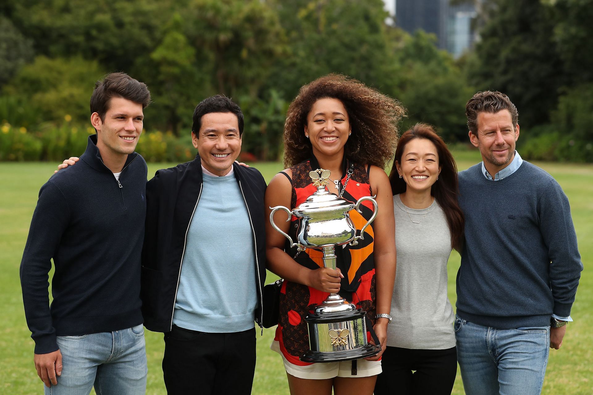 Naomi Osaka poses with her team, including coach Wim Fisette (rightmost), during her photo shoot for winning the 2021 Australian Open title.