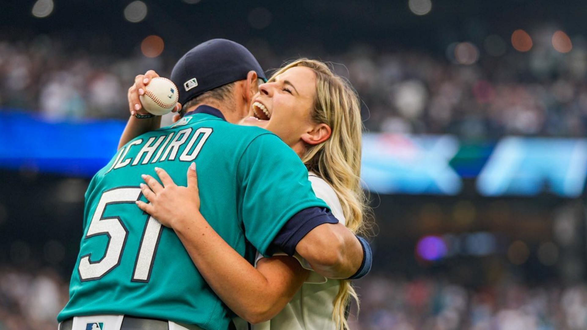 Yumiko Suzuki, right, wife of Seattle Mariners' Ichiro Suzuki and an  unidentified person, left, smile and cheer as they look on following  Ichiro's 200th hit in the second baseball game of a