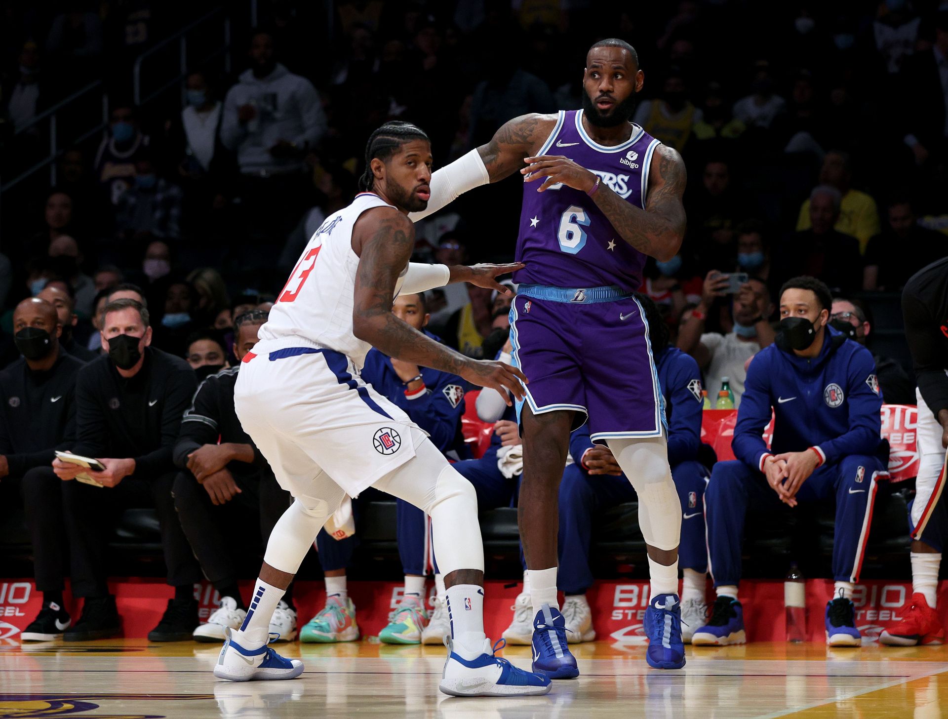 LeBron James #6 of the Los Angeles Lakers and Paul George #13 of the LA Clippers react to a pass during a 119-115 Clippers win over Lakers at Staples Center on December 03, 2021 in Los Angeles, California.