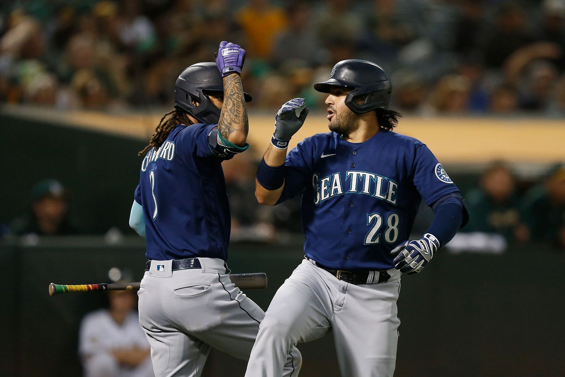 J.P. Crawford celebrates with Eugenio Suarez after Suarez belted a home run during an MLB Seattle Mariners v Oakland Athletics game.