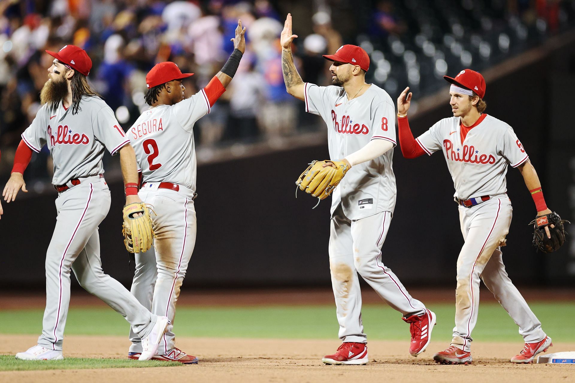 Phillies teammates celebrate after winning in extra innings against the Mets by a score of 2-1.