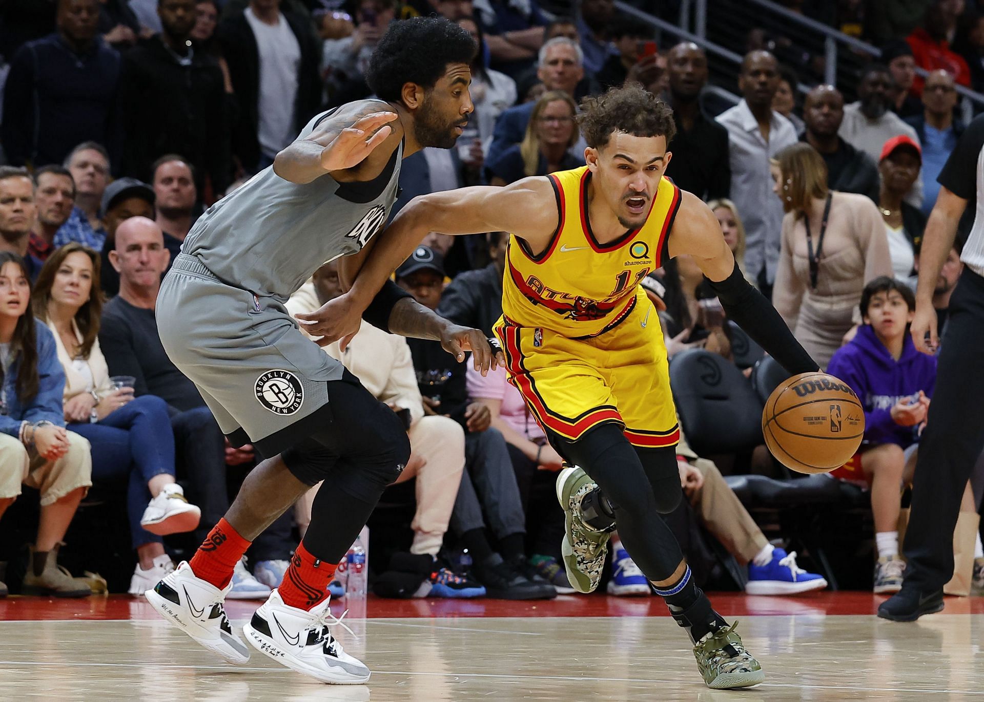 Kyrie Irving of the Brooklyn Nets (left) and Trae Young of the Atlanta Hawks in action during a 2021-22 NBA regular season game