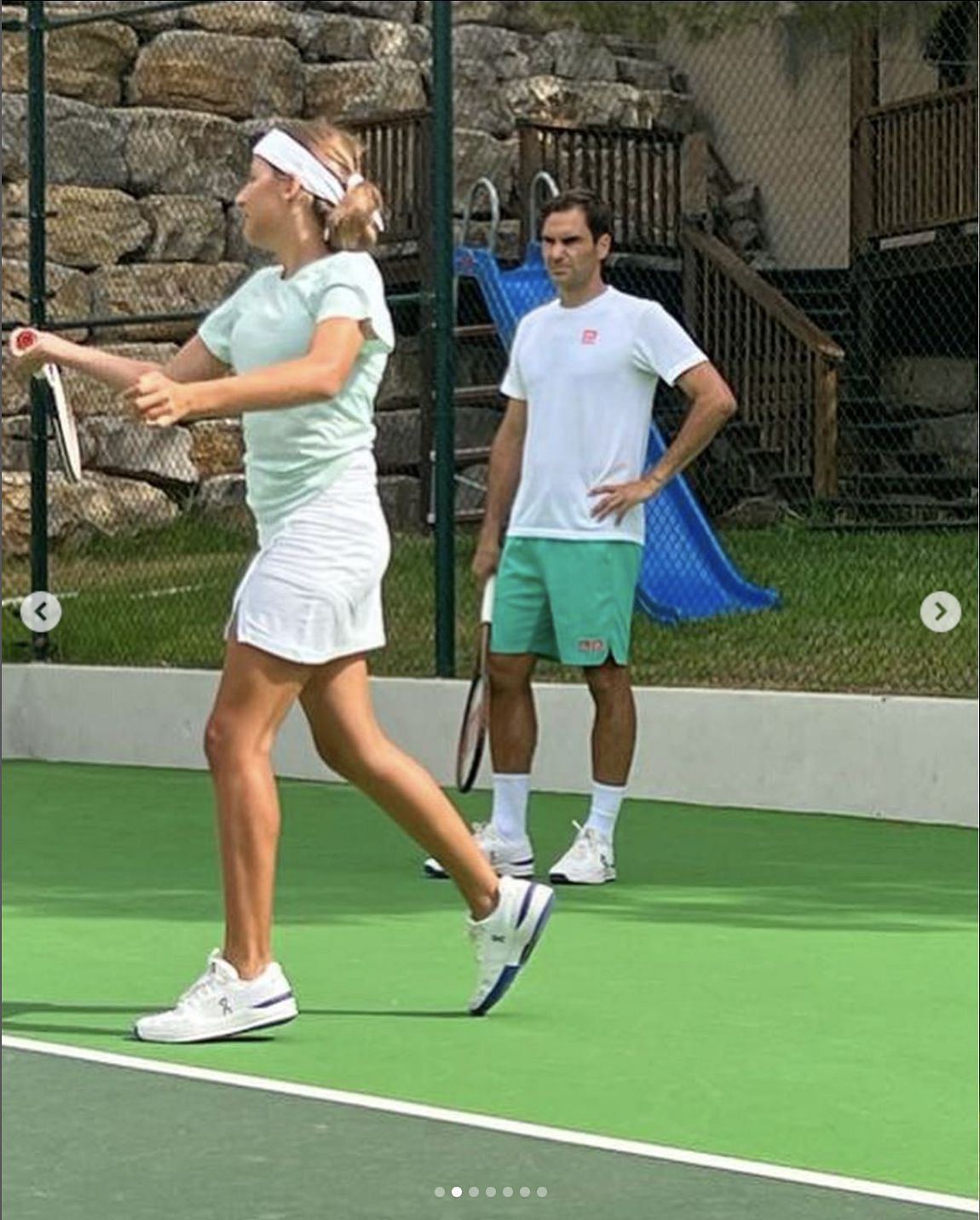 Roger Federer [right] watches his wife Mirka practicing.