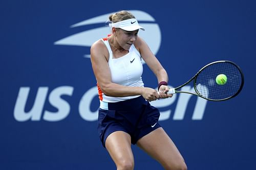 Amanda Anisimova returns a shot against Yulia Putintseva at the 2022 US Open - Day 2