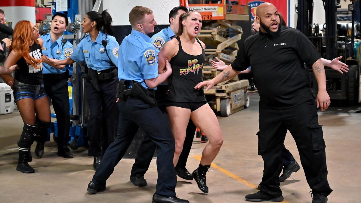 Ronda Rousey being placed under arrest during a wild brawl with Charlotte &amp; Becky Lynch