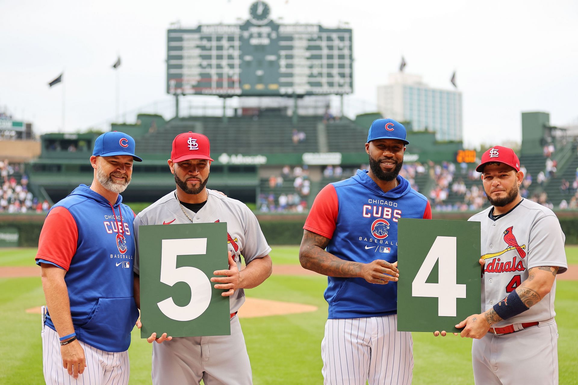 Manager David Ross #3 and Jason Heyward of the Chicago Cubs pose for a photo with Albert Pujols #5 and Yadier Molina #4 during a ceremony ahead of their final career game at Wrigley Field on August 25, 2022