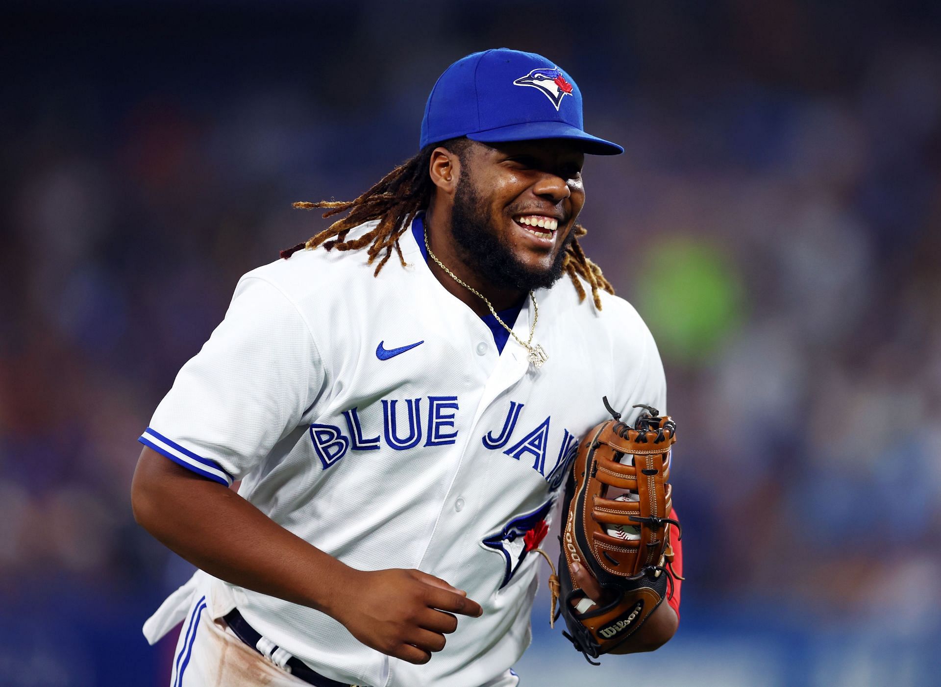 Vladimir Guerrero Jr. smiles while running back to the dugout during a Baltimore Orioles v Toronto Blue Jays game.