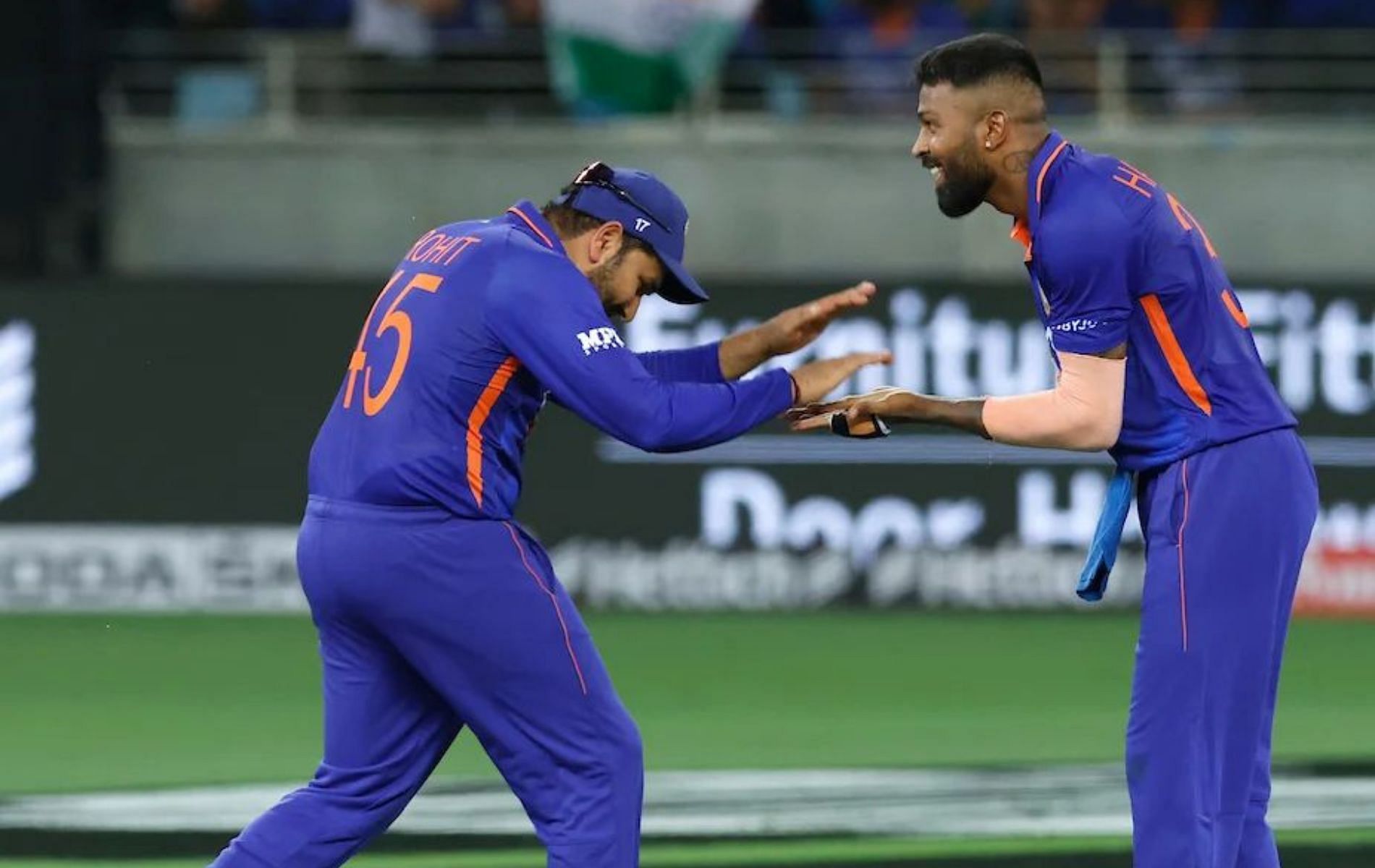 Rohit Sharma (L) celebrates a wicket with Hardik Pandya (R).