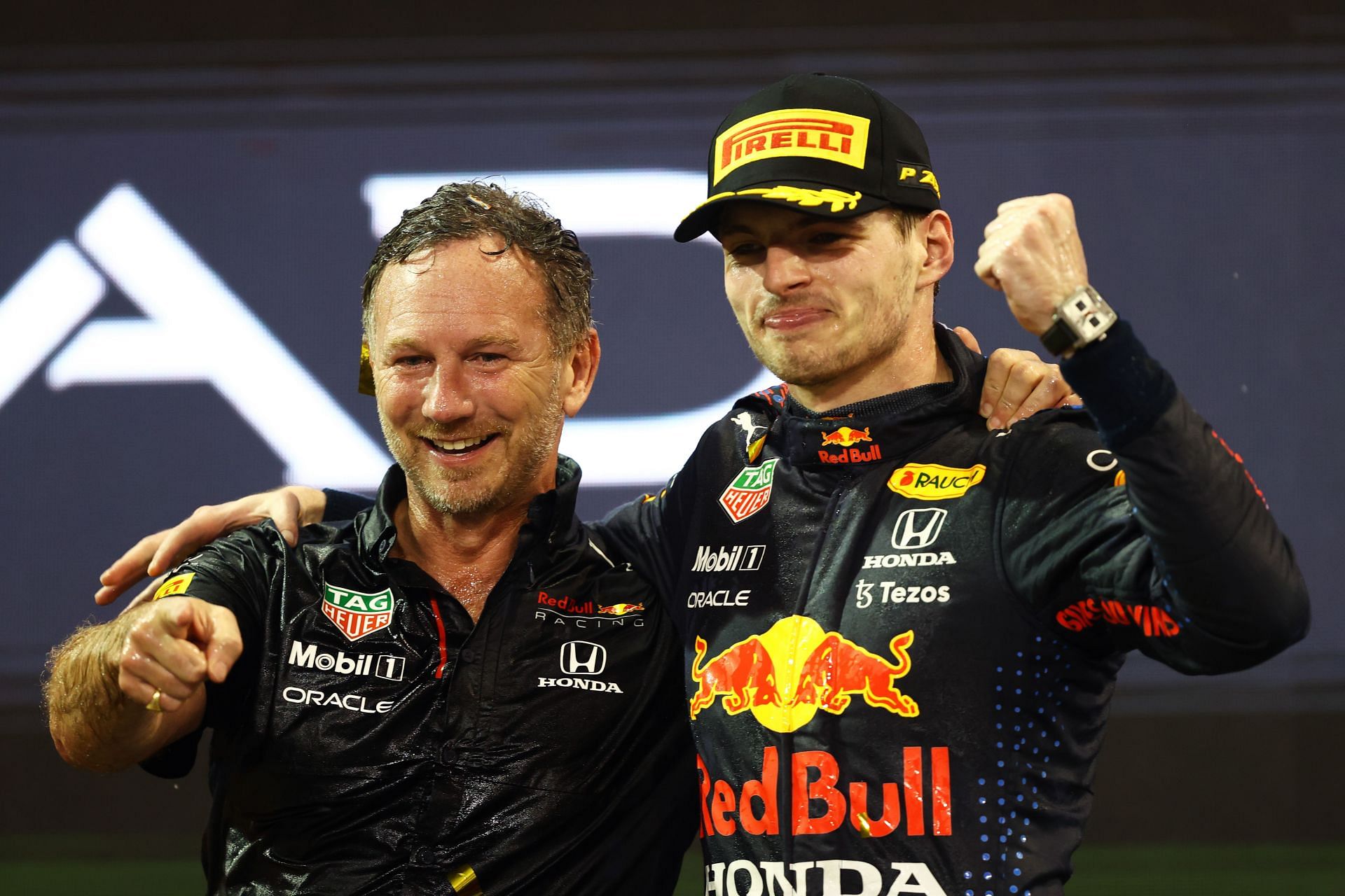 Red Bull team principal Christian Horner (left) and driver Max Verstappen (right) celebrate on the podium at the 2021 F1 Abu Dhabi Grand Prix (Photo by Bryn Lennon/Getty Images)