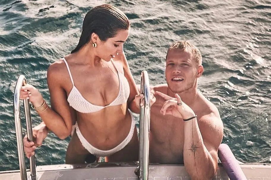 The pair posing on the rail of their boat. Photo via Olivia Culpo Instagram.