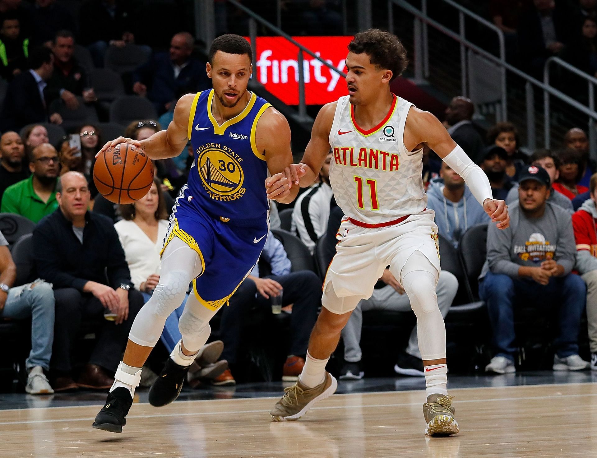 Steph Curry drives past Trae Young.