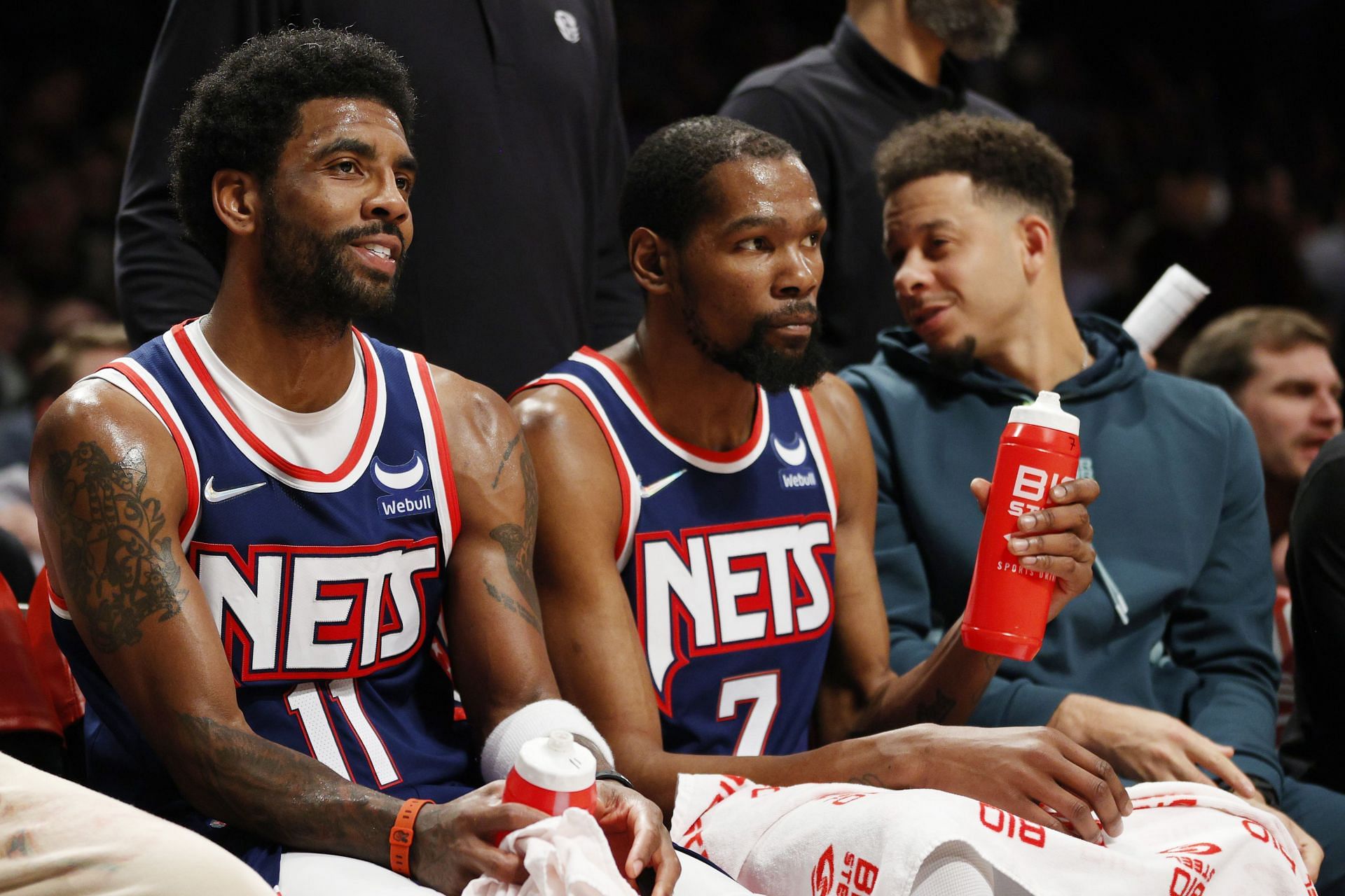 Kyrie Irving, Kevin Durant and Seth Curry watch from the sidelines during Houston Rockets v Brooklyn Nets.