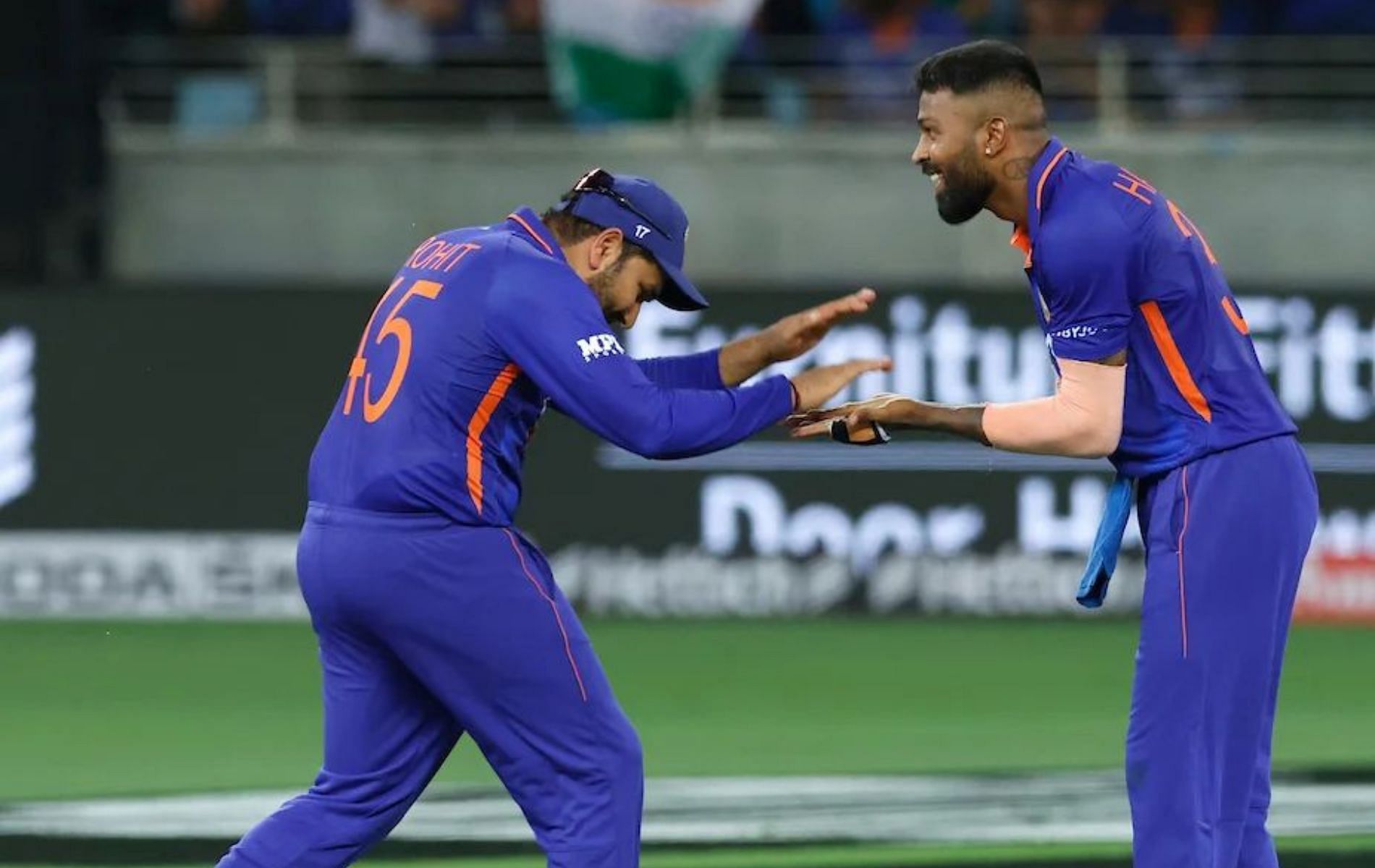 Rohit Sharma (L) celebrates a wicket with Hardik Pandya (R).