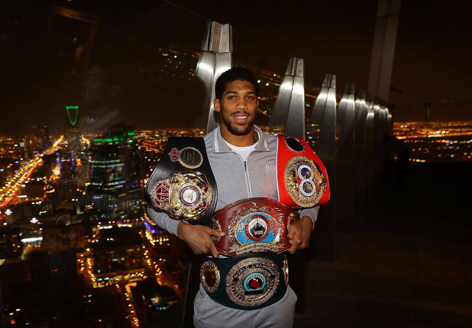 Anthony Joshua with his former world titles