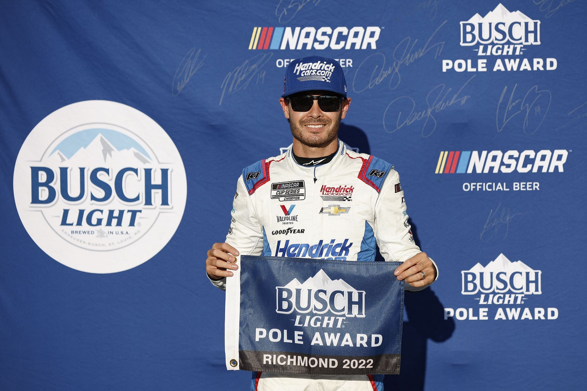 Kyle Larson poses for photos after winning the pole award during qualifying for the NASCAR Cup Series Federated Auto Parts 400 at Richmond Raceway