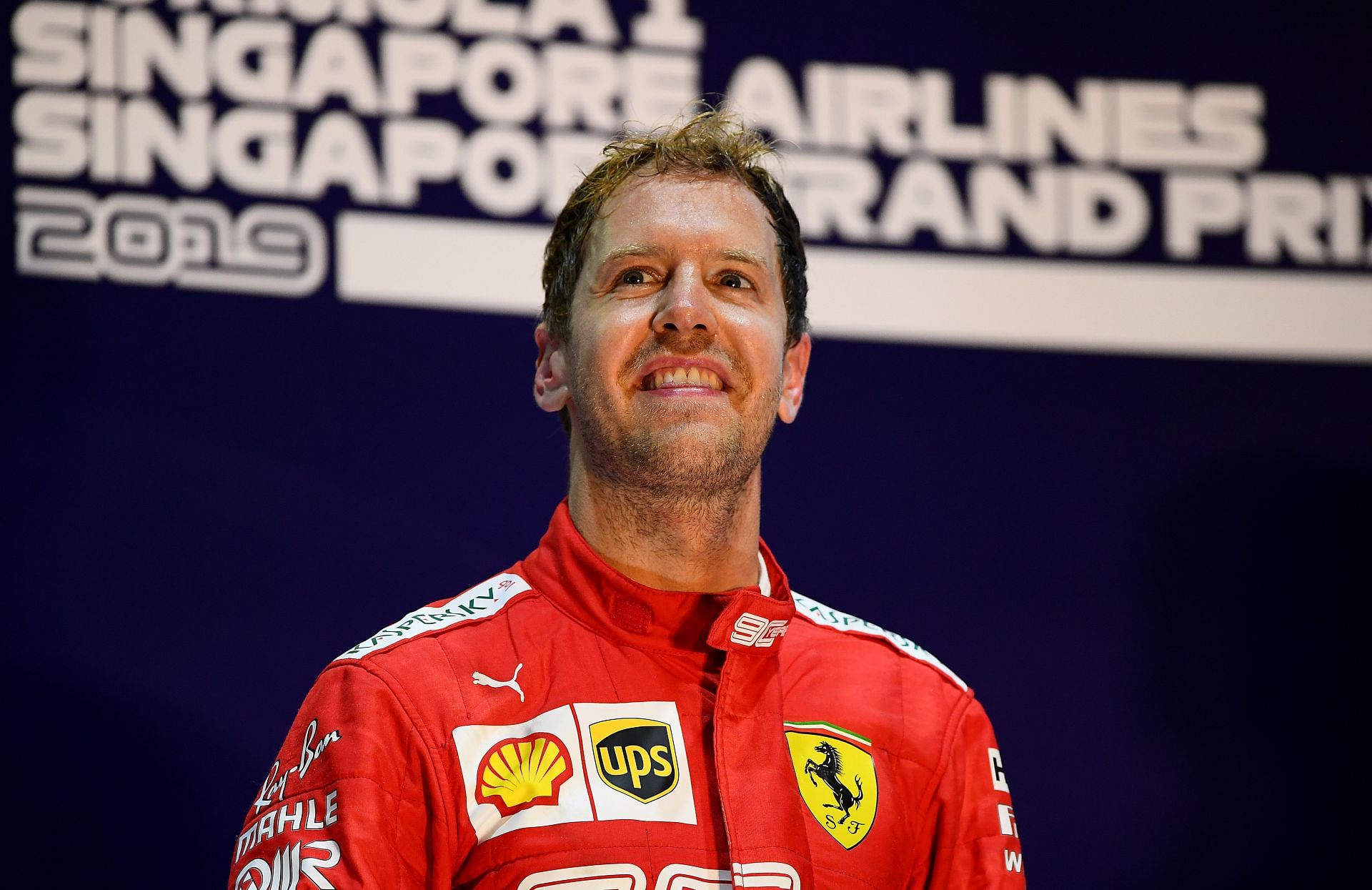 Sebastian Vettel standing on the podium after winning the 2019 F1 Singapore GP with Ferrari (Photo by Clive Mason/Getty Images)