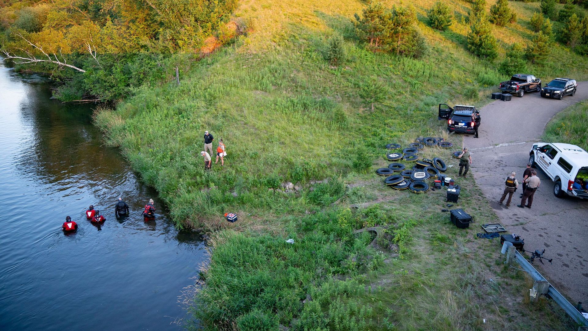 Water recovery personnel at the Apple River after the knife attack (Image via Associated Press)