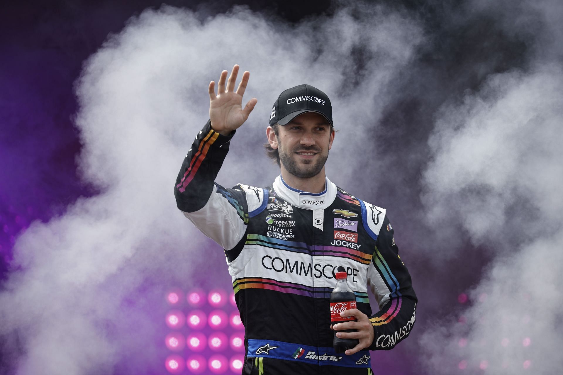 Daniel Su&aacute;rez waves to fans as he walks onstage during driver intros prior to the NASCAR Cup Series Federated Auto Parts 400 at Richmond Raceway