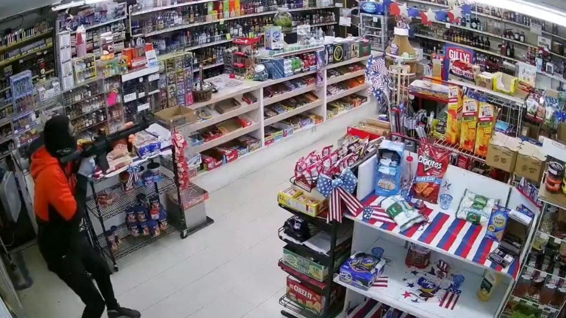 Surveillance footage showed a masked and armed robber aiming his rifle at a California store owner seconds before he was shot in the arm instead (Image via YouTube)