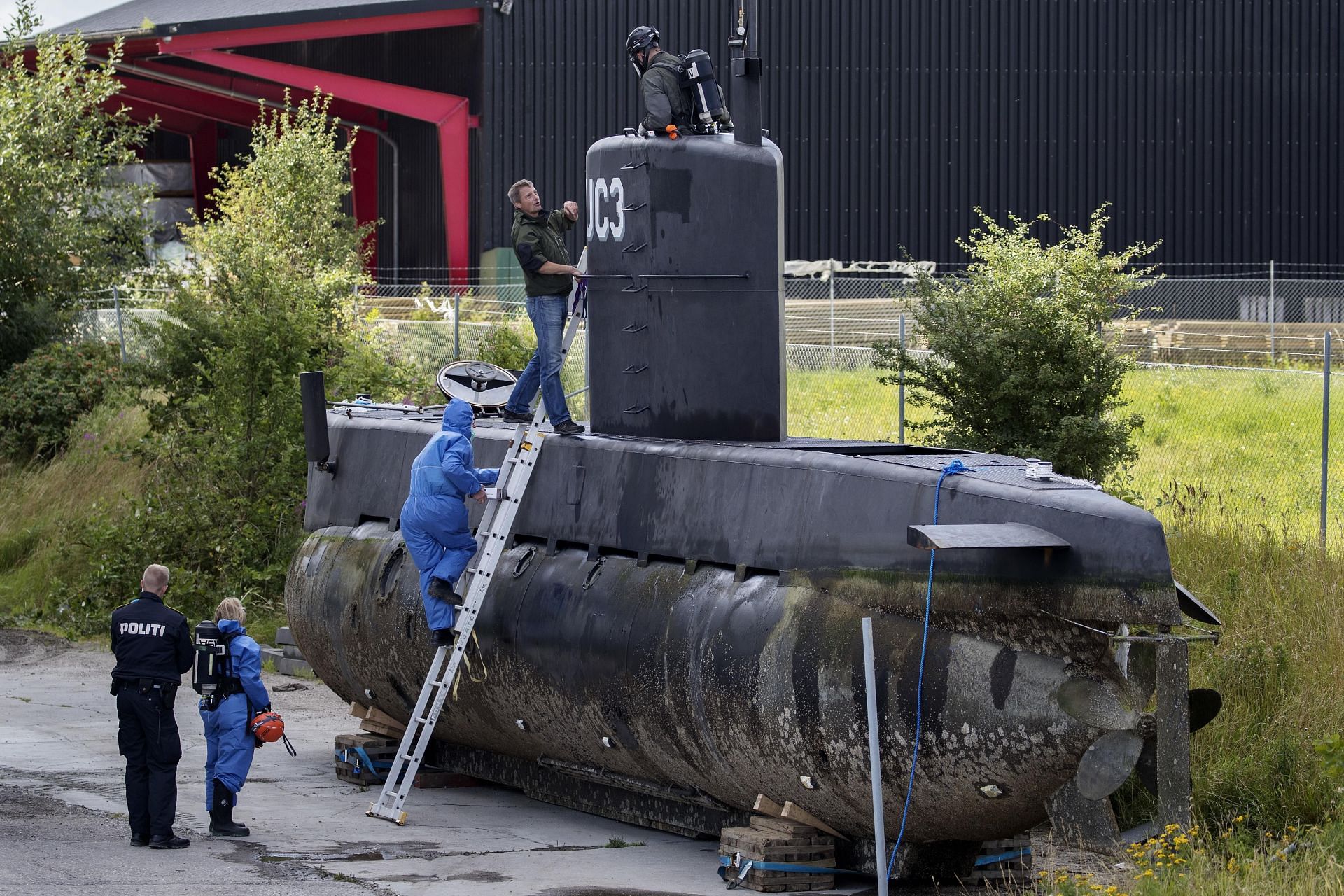 Police enter the salvaged UC3 Nautilus (Image via AP)