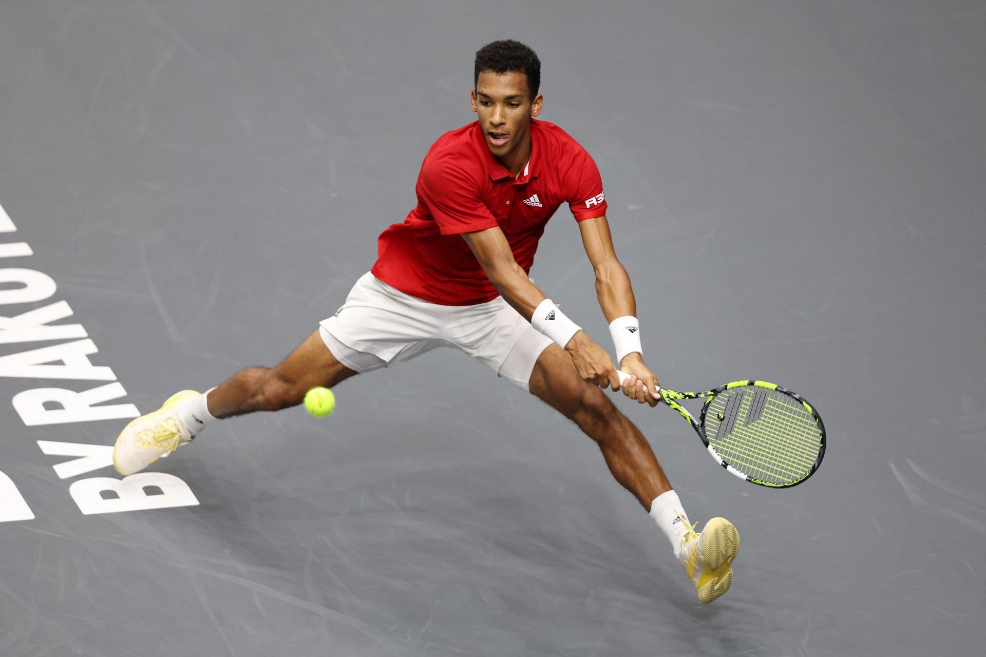 Felix Auger Aliassime plays a backhand against Carlos Alcaraz at the Davis Cup