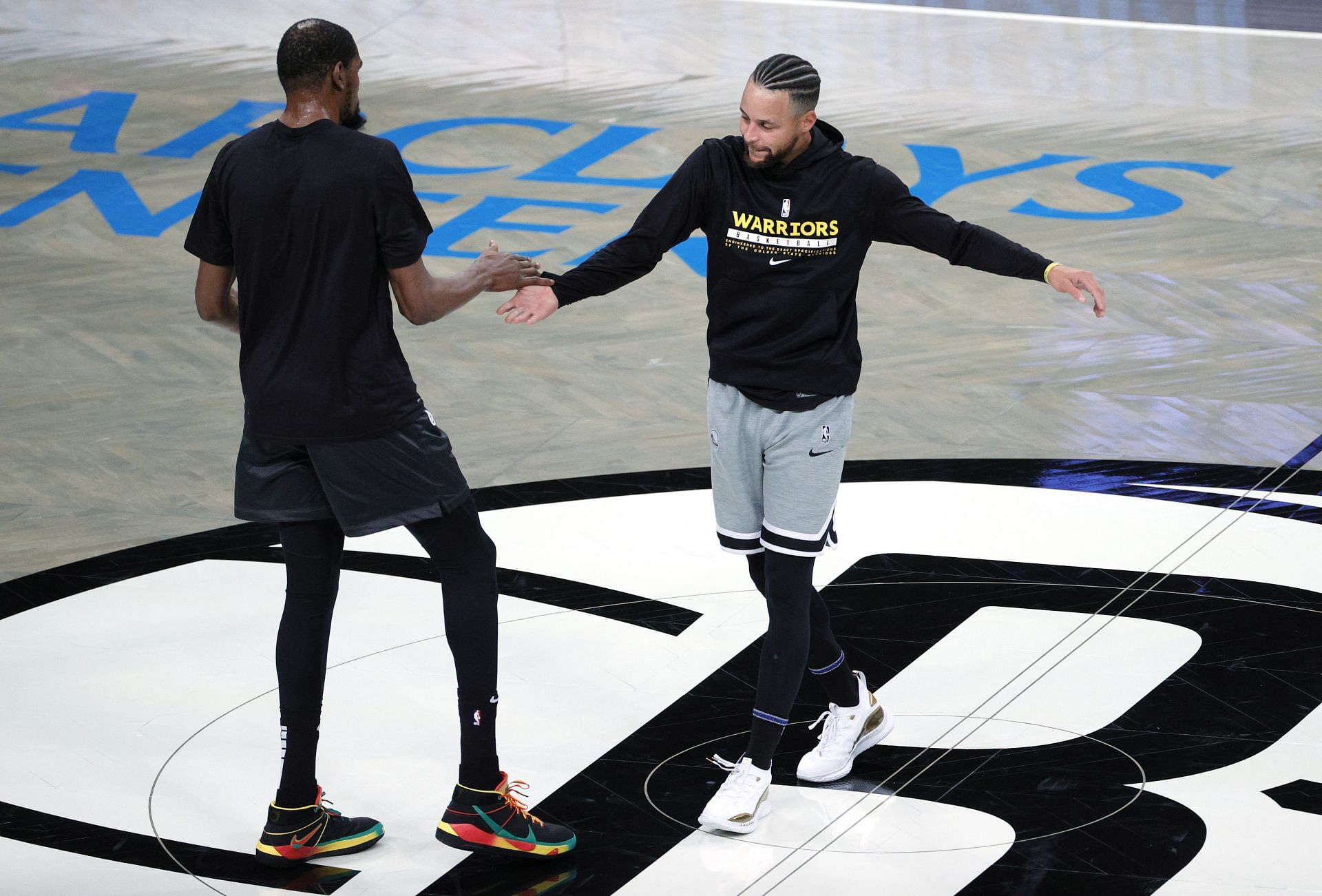Steph Curry and Kevin Durant greet each other before a game