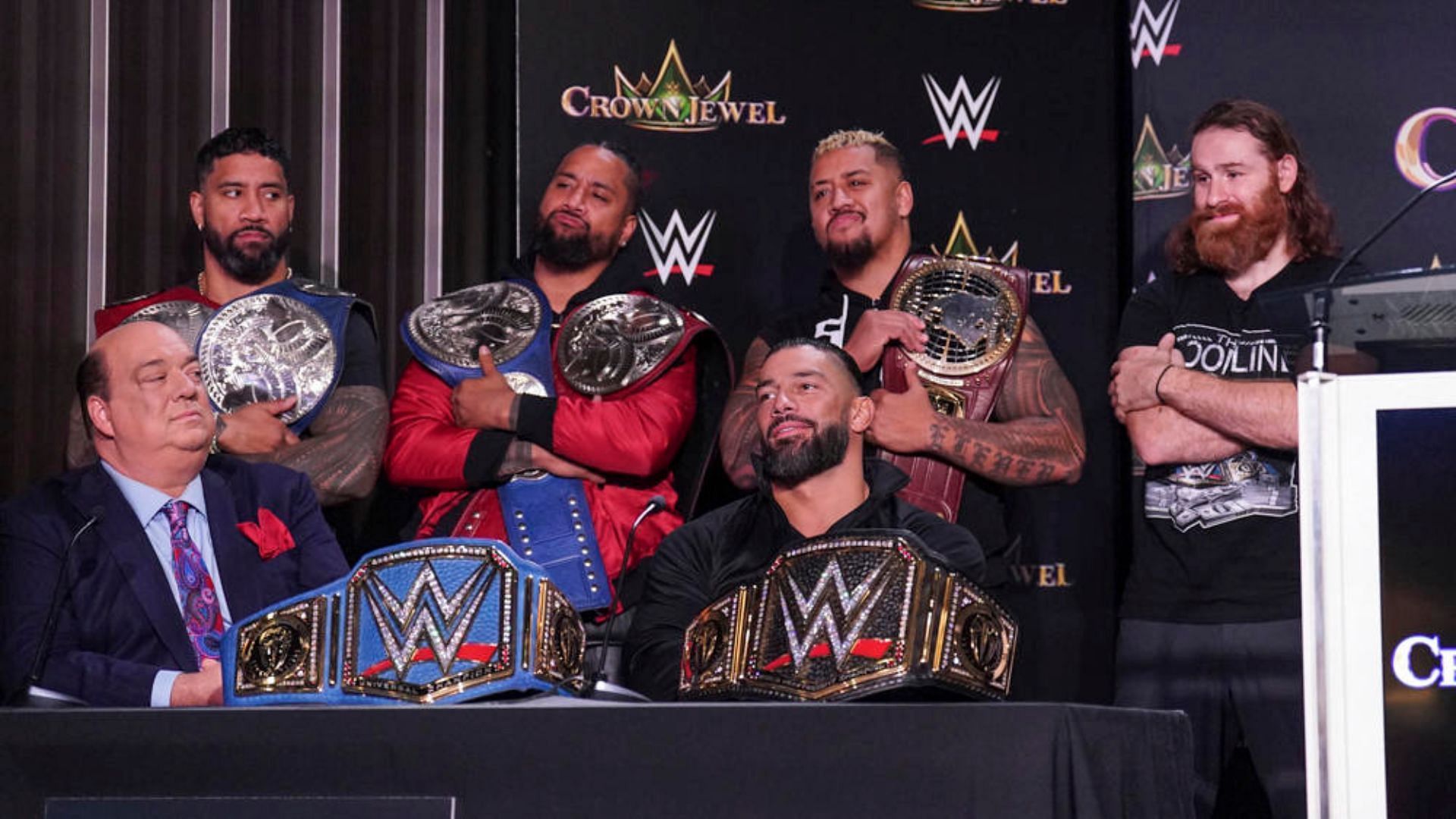 The Bloodline with their respective championships at the recent Crown Jewel press conference