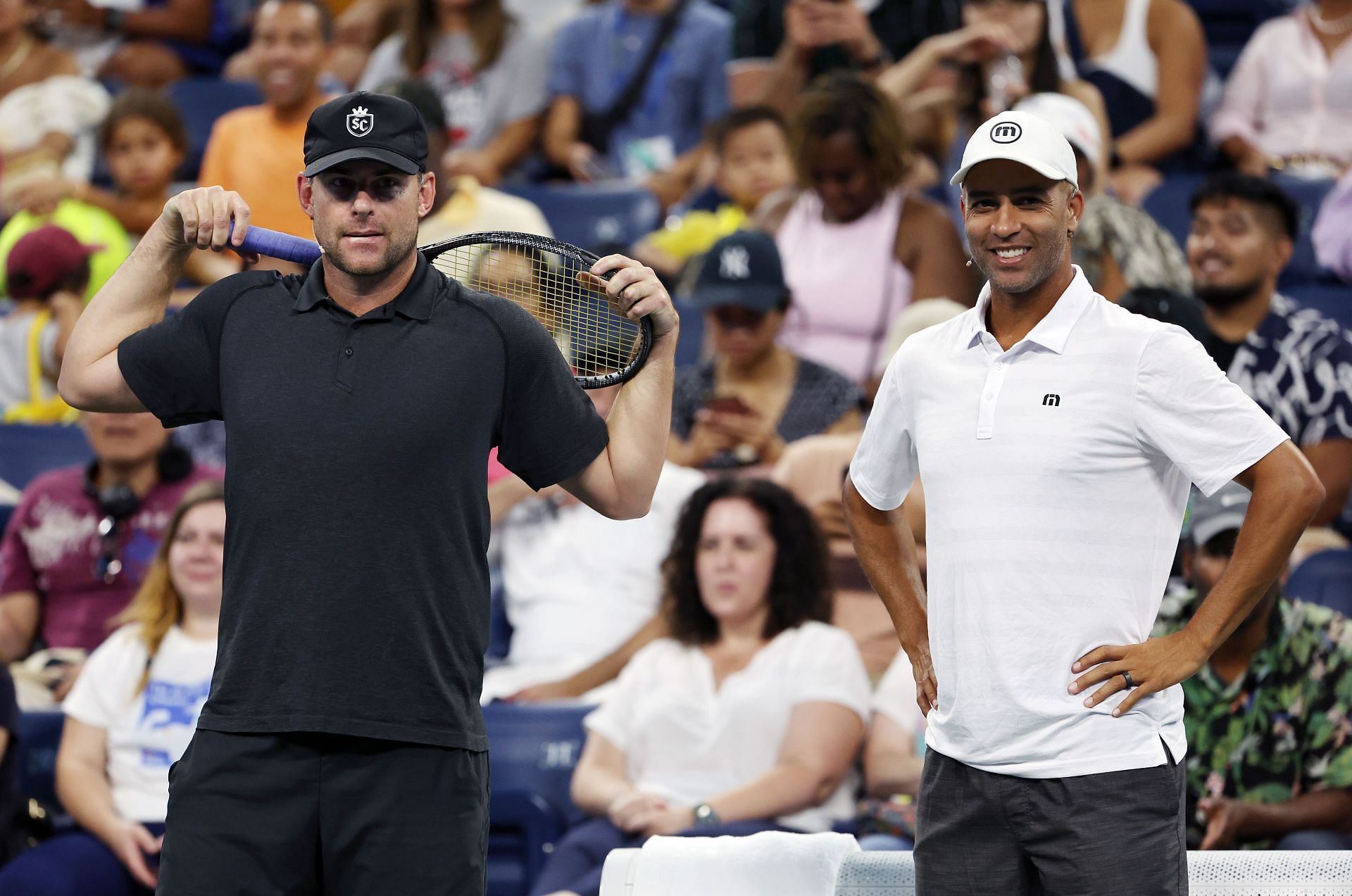 Andy Roddick and James Blake watch Kim Clijsters and Bethanie Mattek-Sands play during the US Open Legends Match at the 2022 US Open 