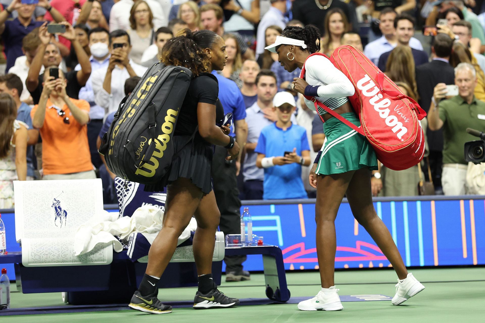 Serena Williams and Venus Williams prepare to leave the court at the 2022 US Open - Day 4