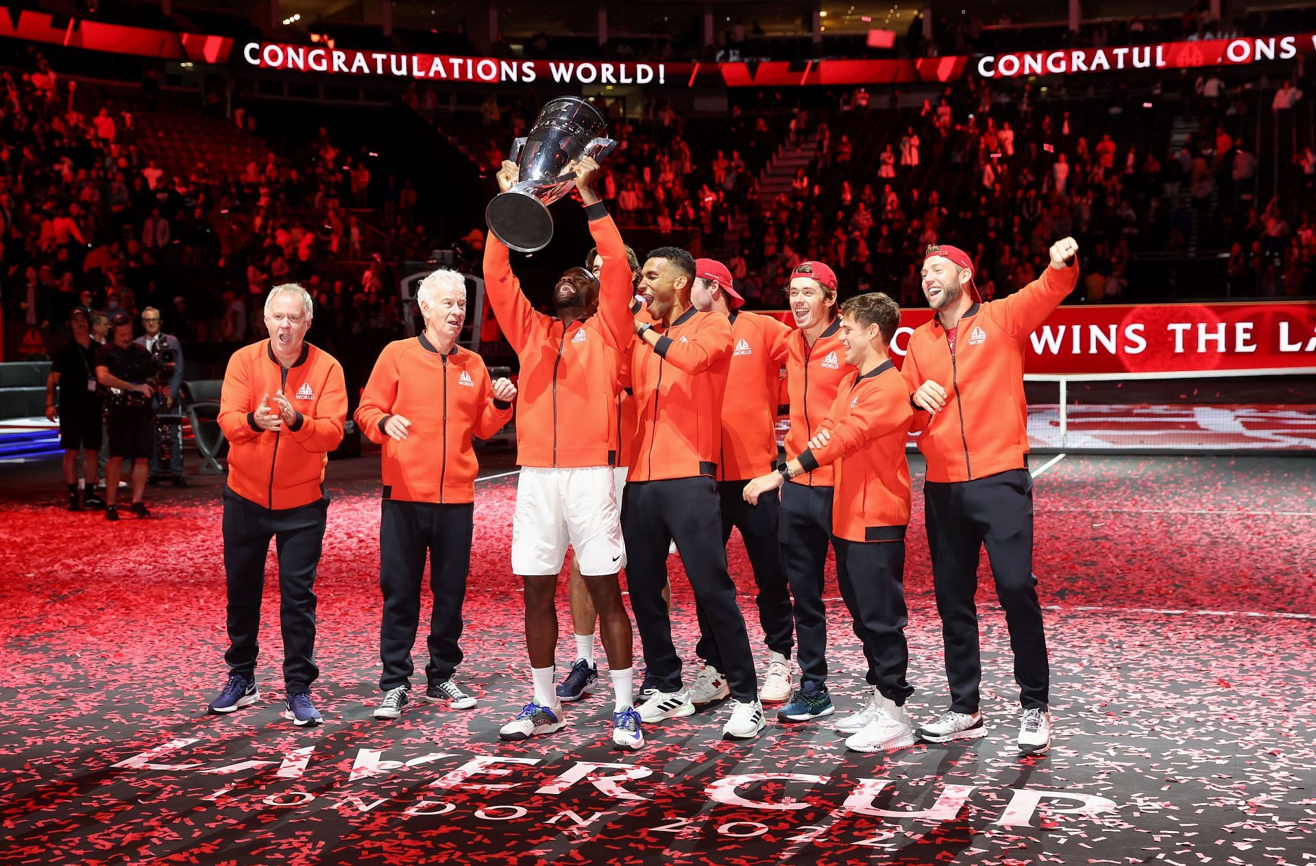Frances Tiafoe hoists the Laver Cup trophy as Team World celebrates its maiden win at the tournament.