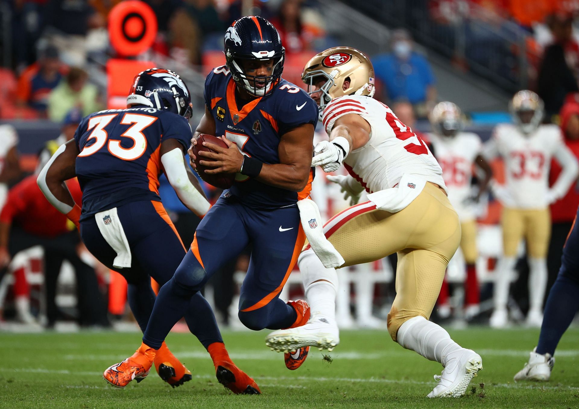 Russell Wilson of the Denver Broncos is tripped by Nick Bosa