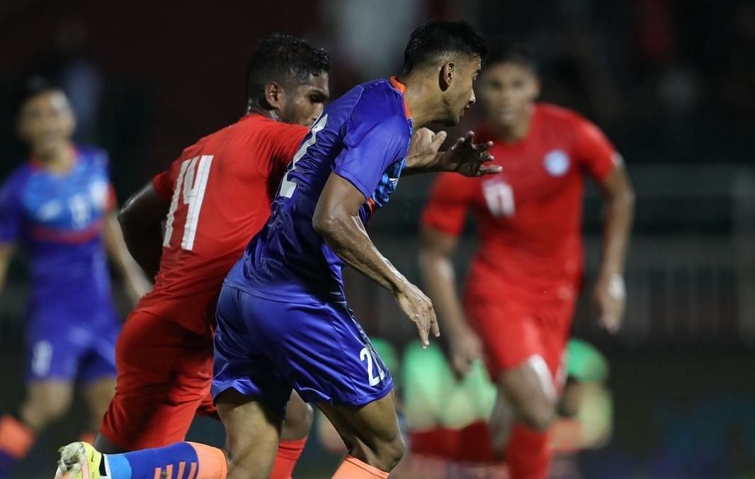 Ashique Kuruniyan tussling for the ball against Singapore defenders.