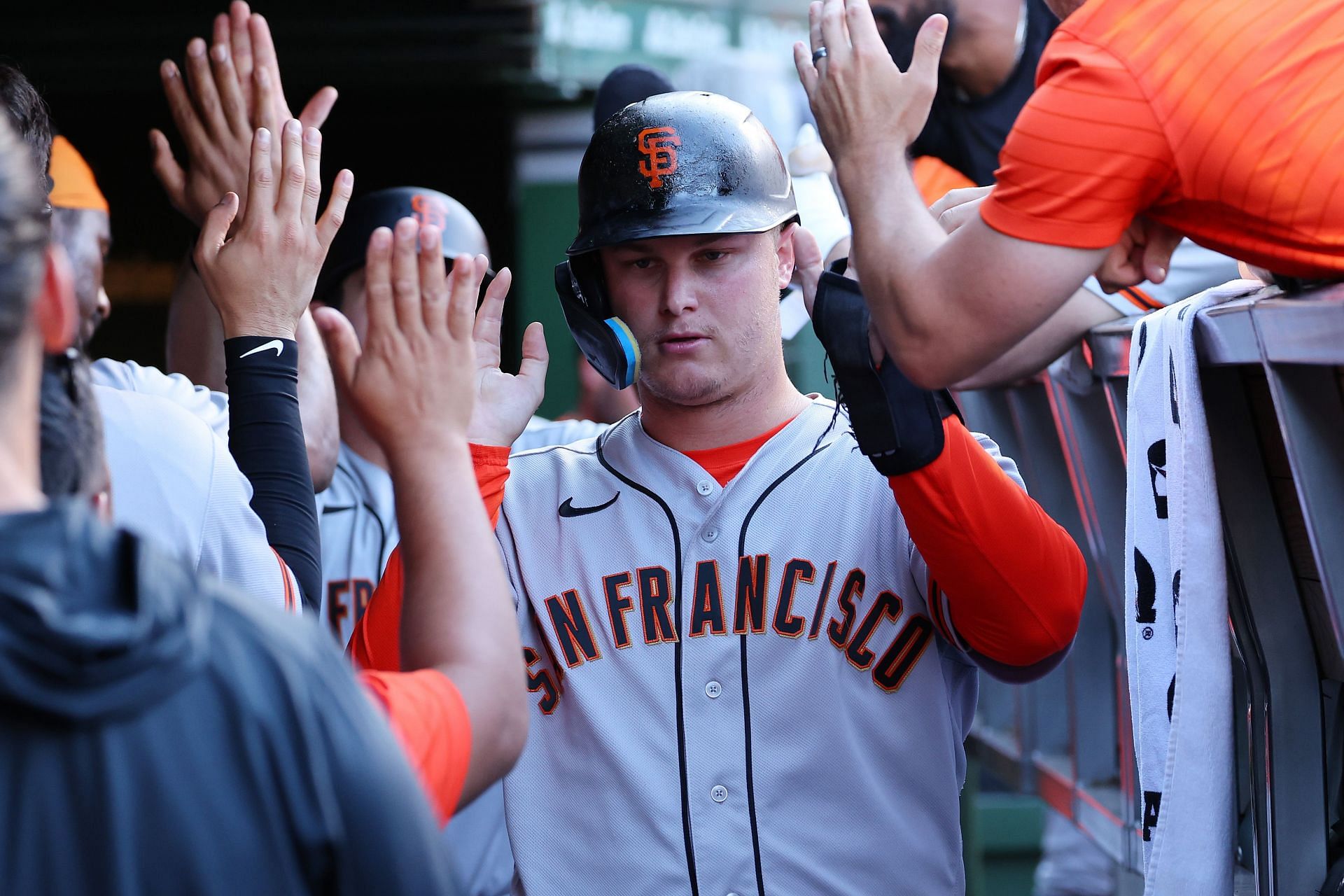 Joc Pederson of the San Francisco Giants high fives teammates after scoring a run against the Chicago Cubs.