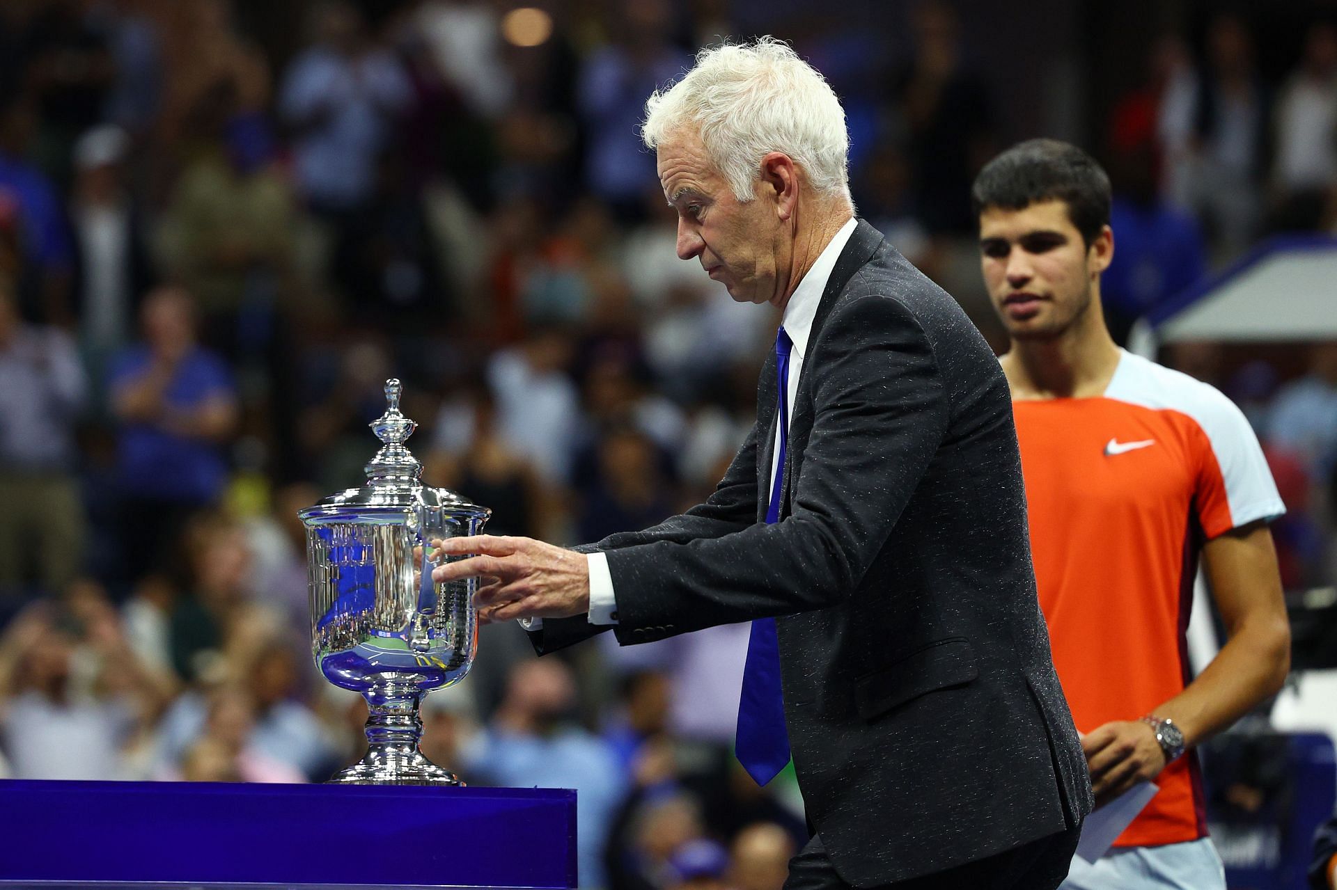 John McEnroe presents the 2022 US Open trophy to Carlos Alcaraz.