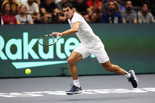 Carlos Alcaraz runs to play a forehand against Felix Auger-Aliassime at the Davis Cup 