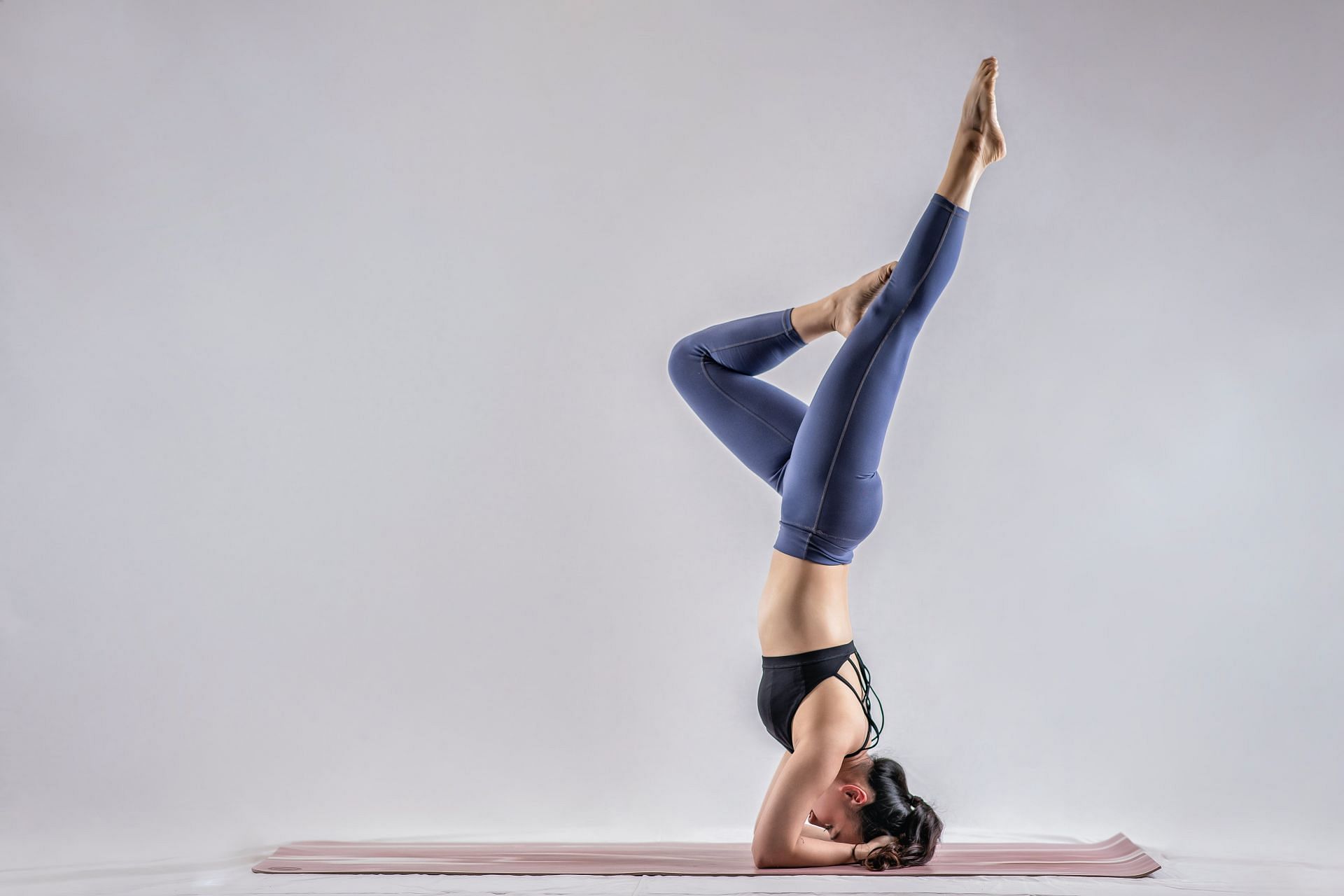 Supported headstands can be challenging, but the best method for safety is to develop the pose from the ground up. (Image via Unsplash/ Ara Cho)