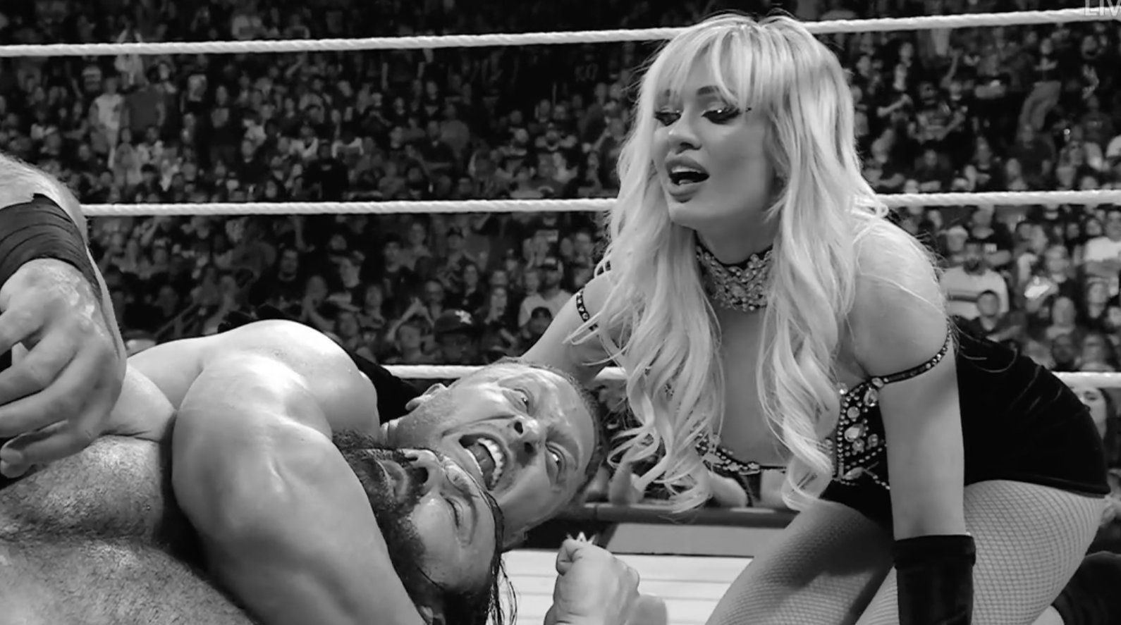 Karrion Kross choking out Drew McIntyre as Scarlett looks on 
