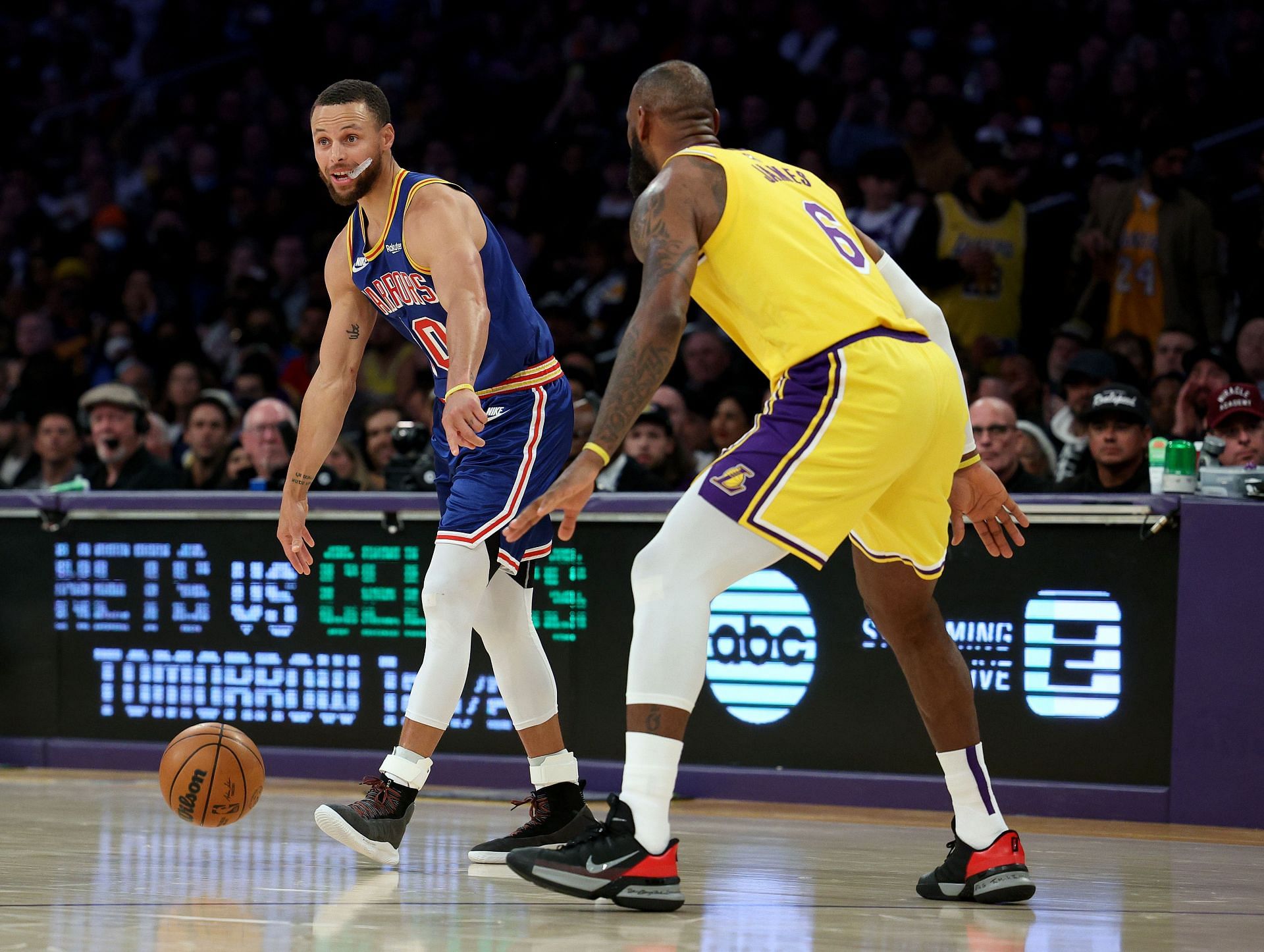 Stephen Curry of the Golden State Warriors dribbles in front of LeBron James of the Los Angeles Lakers
