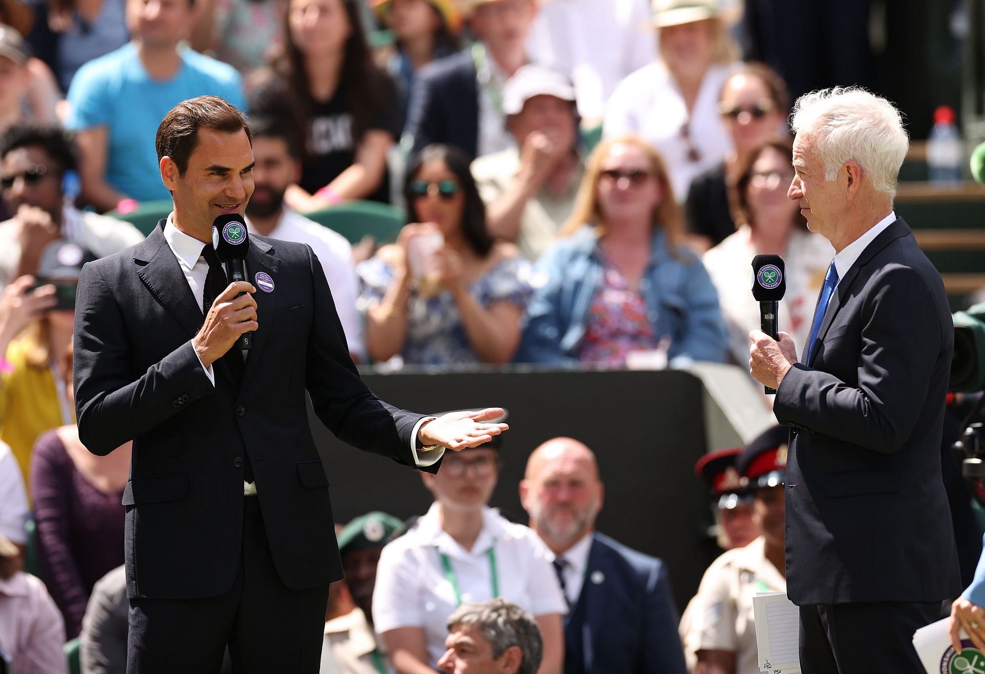 Roger Federer (L) and John McEnroe look on during the Centre Court Centenary Celebration