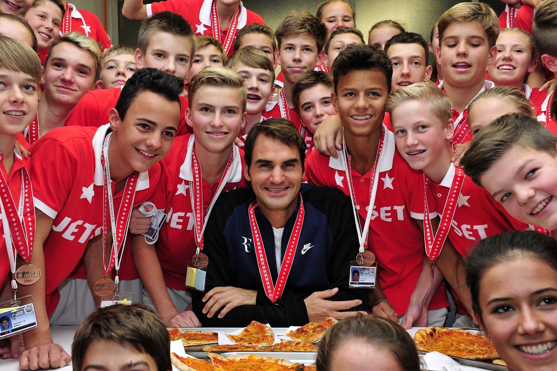 Roger Federer shares pizza with the ball kids in Basel in 2015.