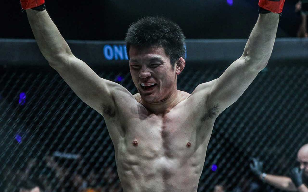 Japanese fighting legend Shinya Aoki with arms raised 