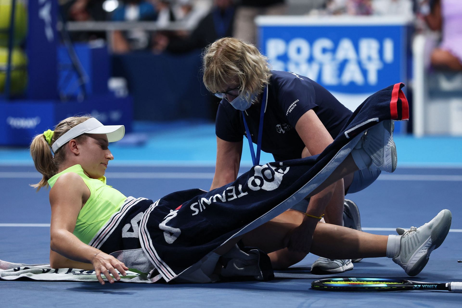 Daria Saville (L) of Australia receives medical attention in the Singles first round match against Naomi Osaka at the Toray Pan Pacific Open - Day Two