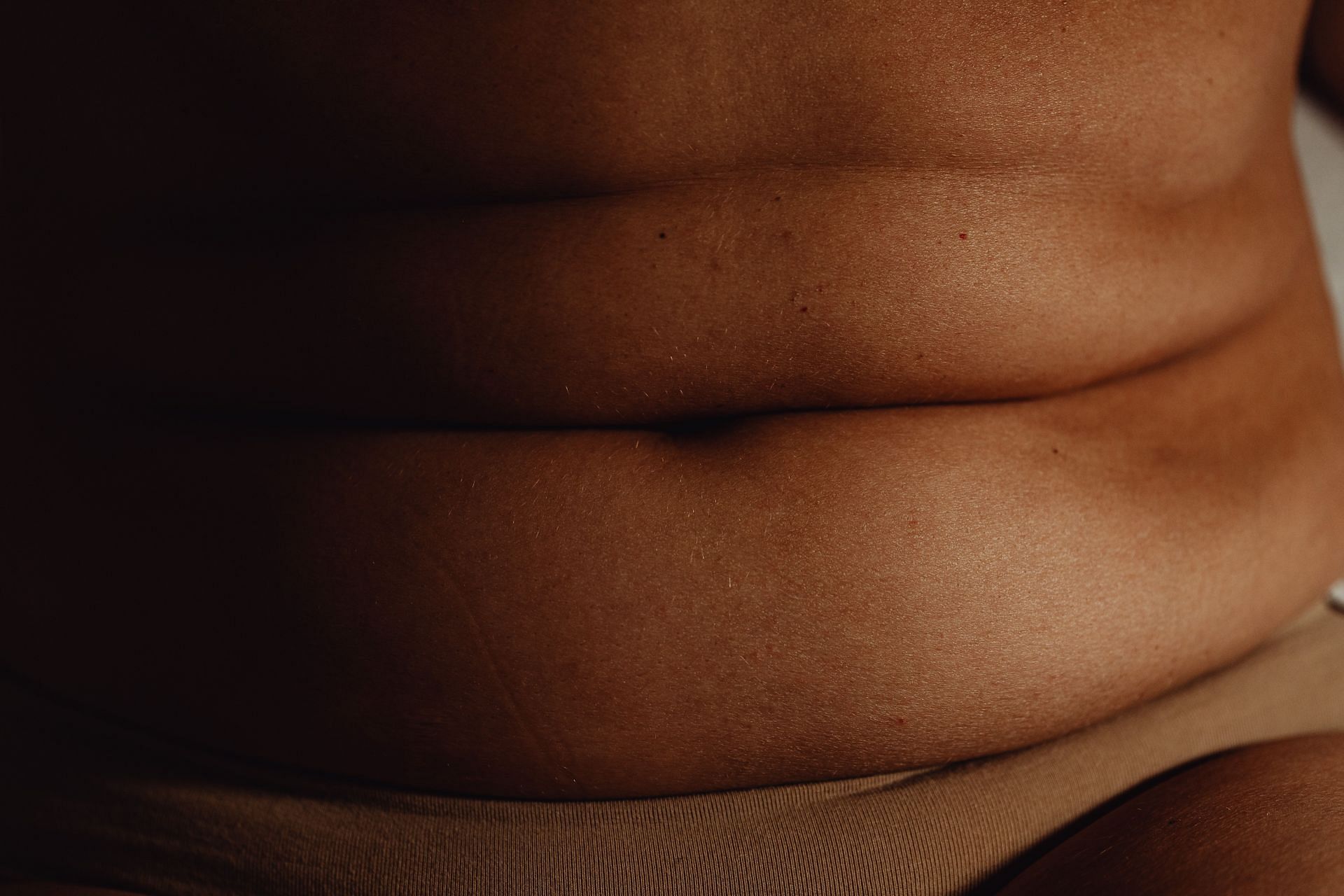 Strength training exercises combined with diet can help reduce belly overhang. (Image via Pexels /Karolina Garabowska)
